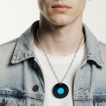 Man wearing a denim jacket and necklace with a blue pendant on a white background