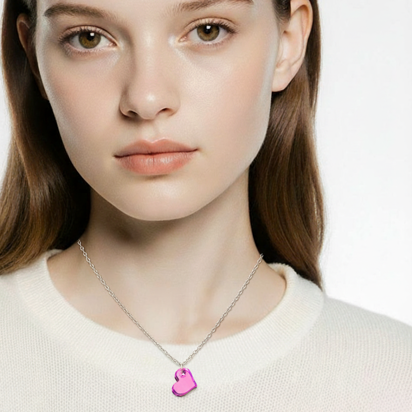 Woman wearing a necklace with a pink heart pendant on a plain background