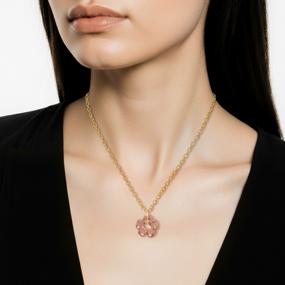 Necklace with a pink pendant worn by a person in a black outfit