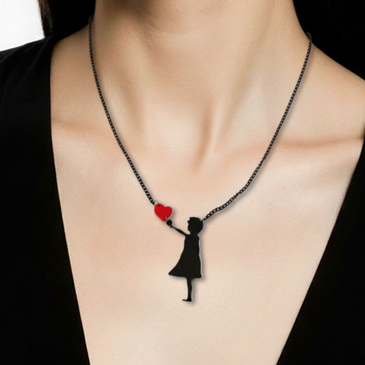 Necklace with a pendant of a woman holding a heart, worn by a person in a black top.